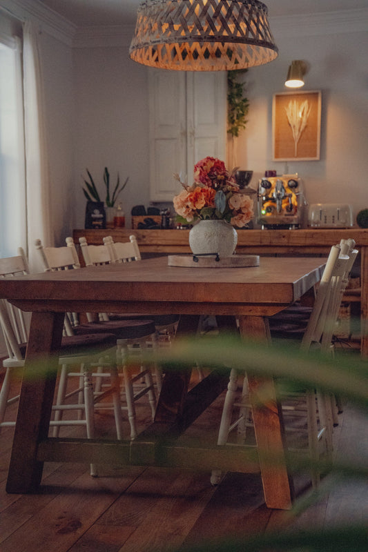 Table en bois massif Atelier Arbor dressée dans une salle à manger chaleureuse, prête pour le repas de famille